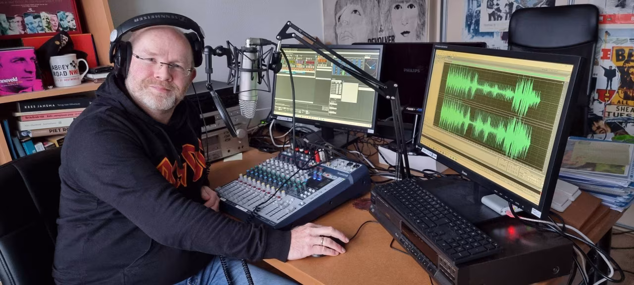 Opname studio met mengpaneel en microfoon, twee schermen tonen audio software en geluidsgolven - So Many Roads Twents tintje op Grolloo Radio