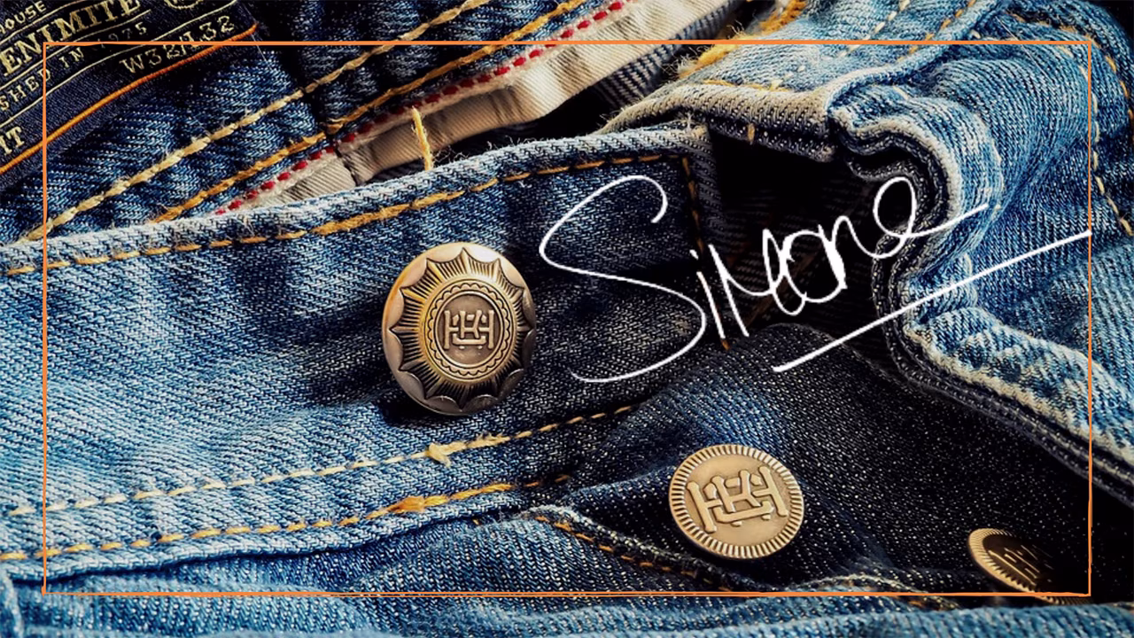 Close-up spijkerbroek met stervormige metalen knopen en handschrift 'Simone', tips voor langer plezier van jeans