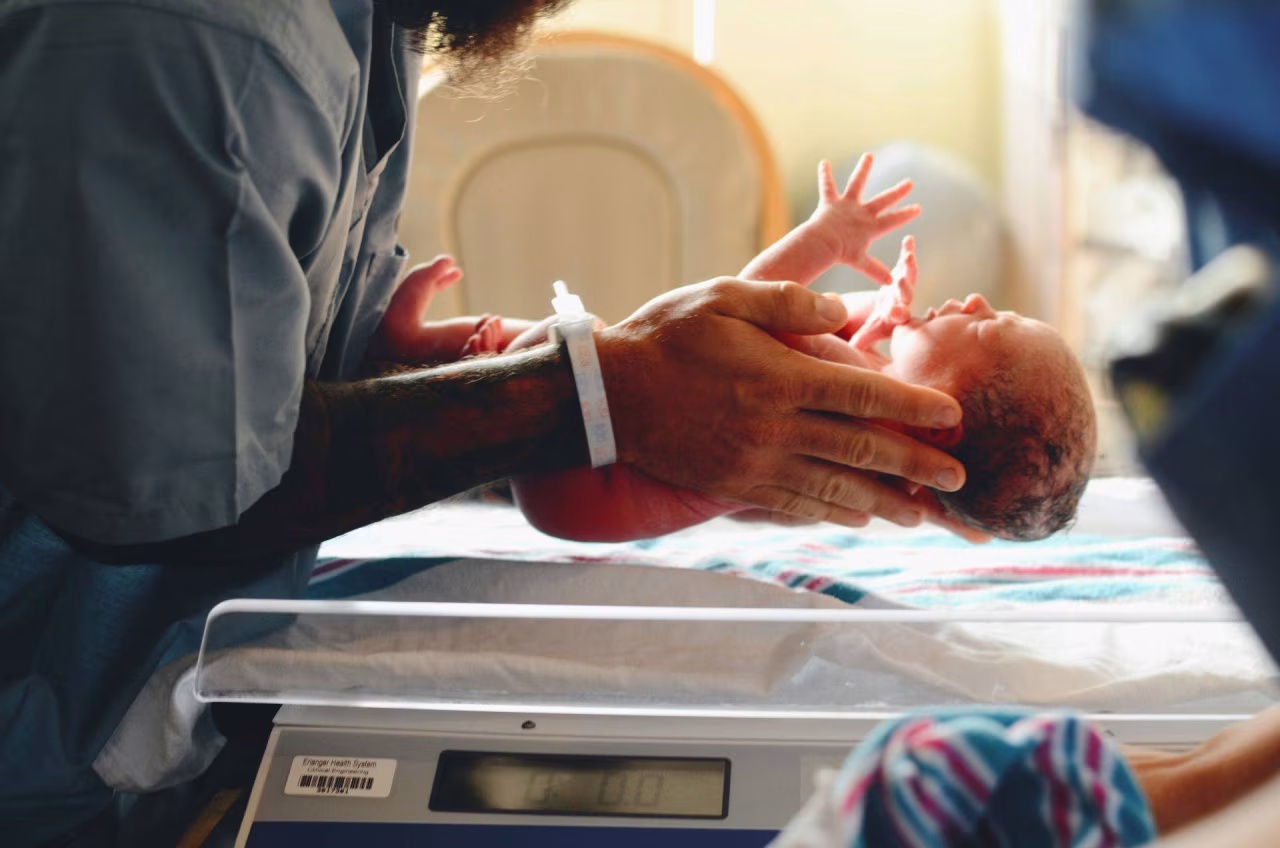 Pasgeboren baby op digitale weegschaal gewogen in ziekenhuiscontext bij ruims 60 landen bevolking krimpt