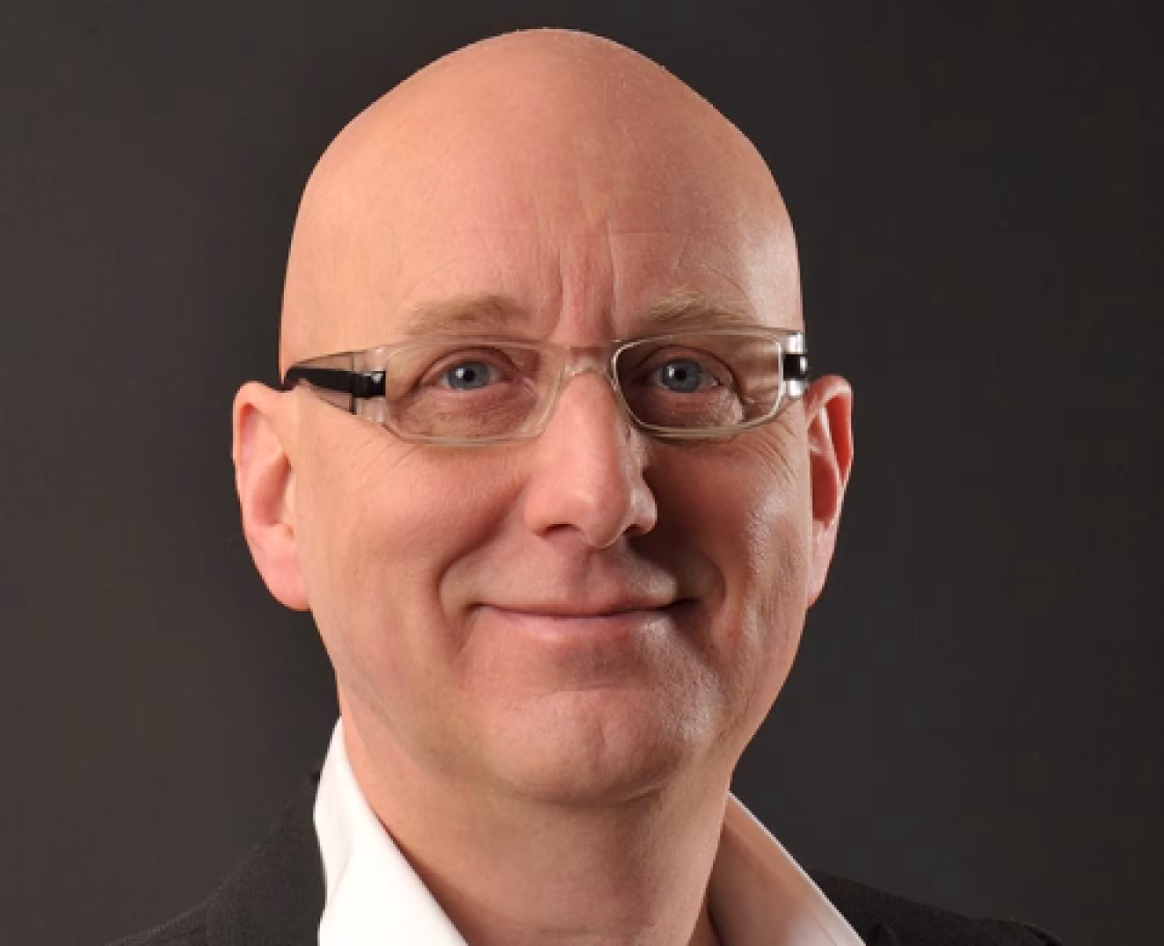 Hoofdportret van René Jager met bril, thema 'Twente is één grote proatmesjien' over leiderschap in Twente