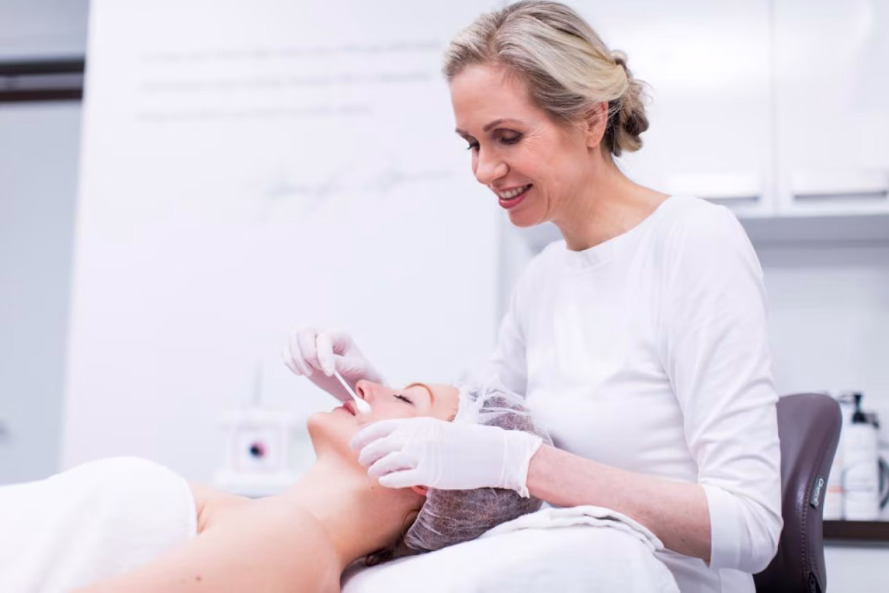 Last van acne? Huidtherapeut voert manuele acnebehandeling uit in professionele behandelkamer met witte handschoenen