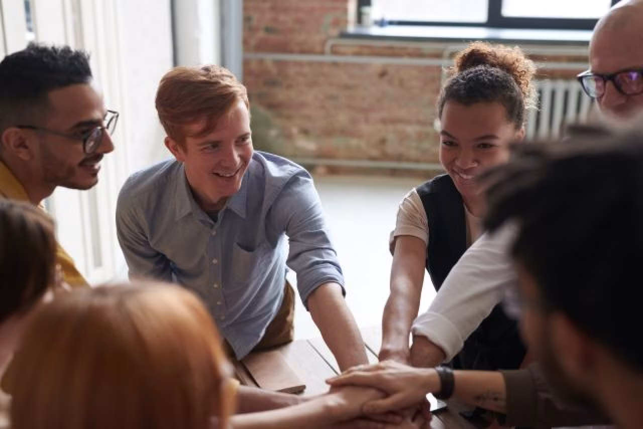 Groep jonge mensen stapelen handen als teken van samenwerking Over nut en noodzaak van een netwerk voor jongeren