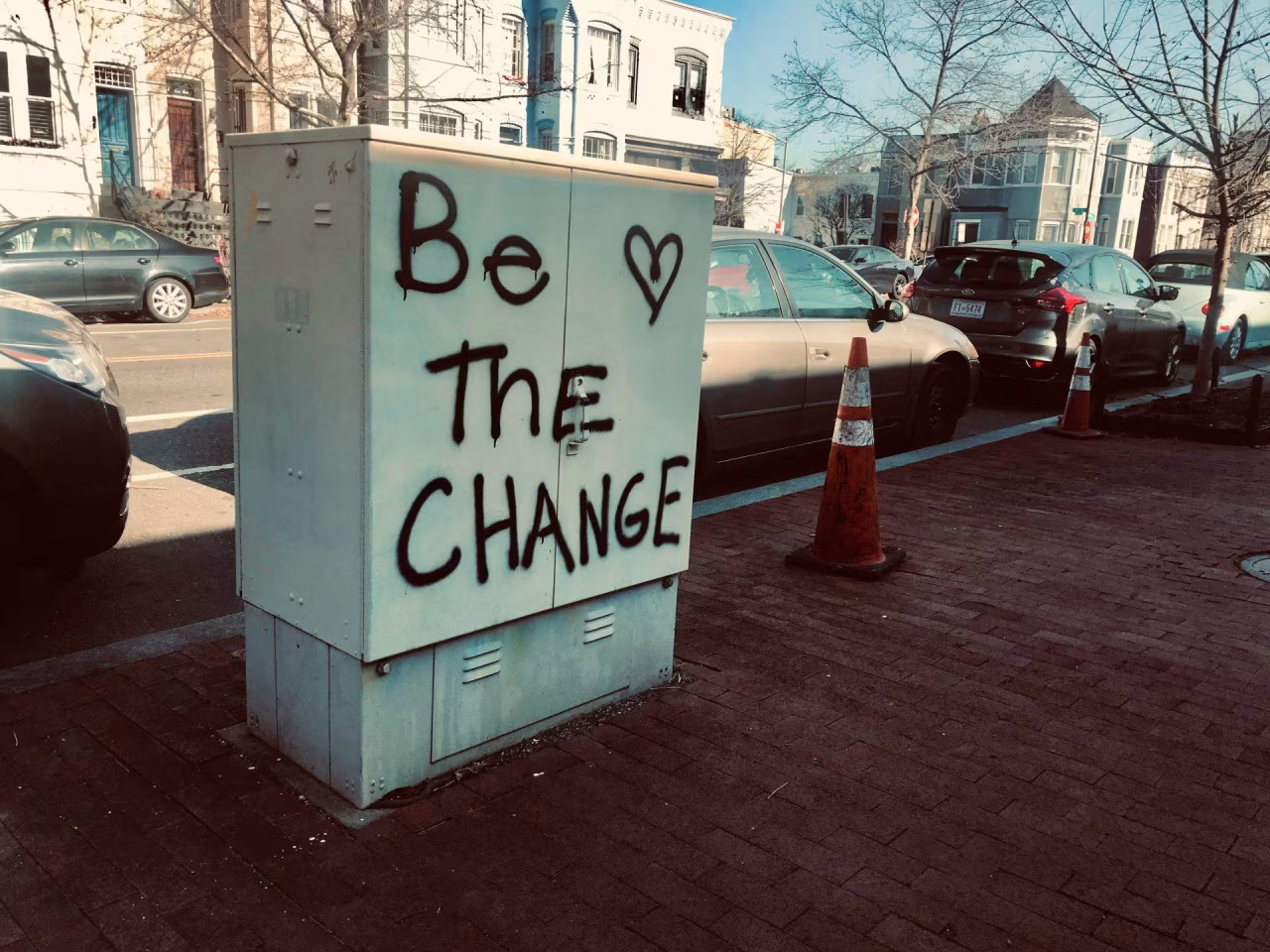 Elektriciteitskast met tekst be the change en zwart hartje langs straat in twente noaberschap niet meer van deze tijd