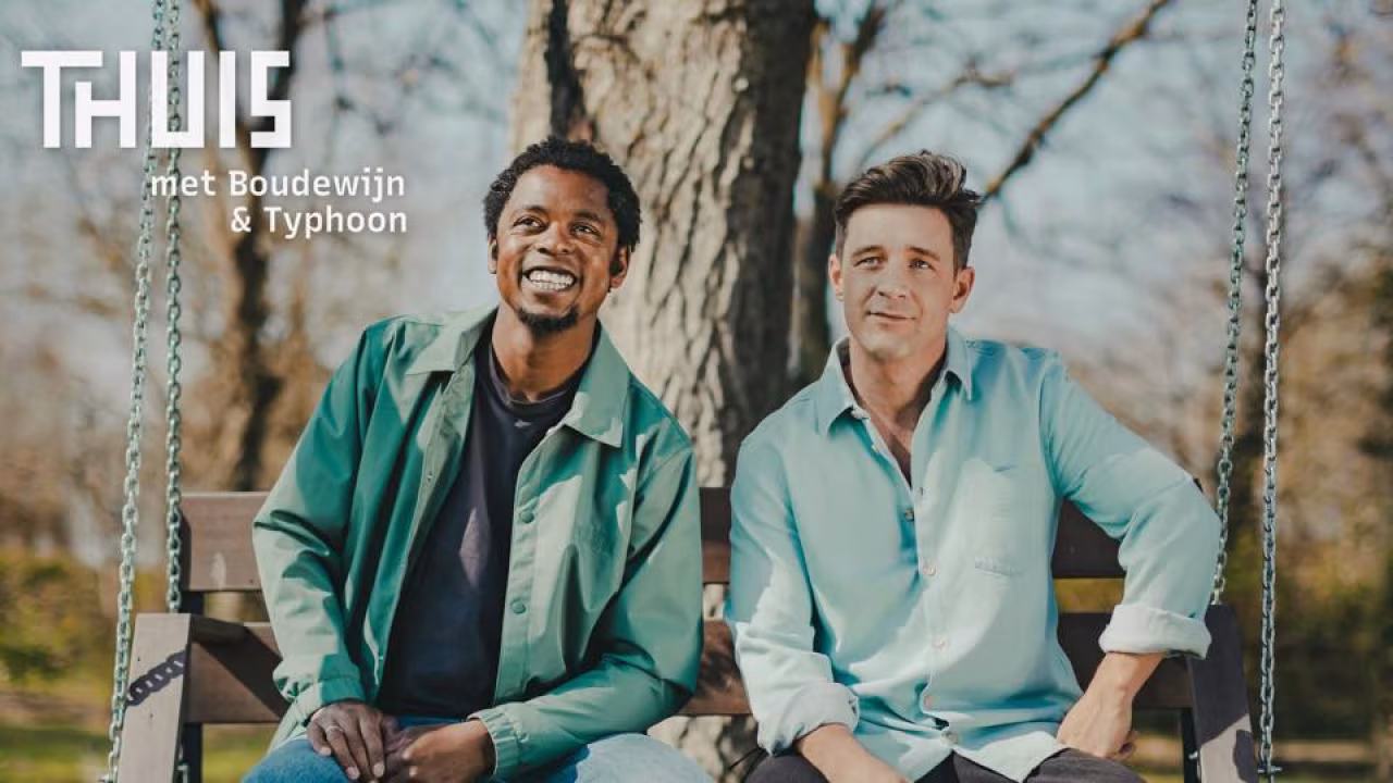 Thuis met boudewijn & typhoon: twee zittende personen op een houten schommel, natuurlijke buitenomgeving met bomen, promotie talkshow week van diversiteit
