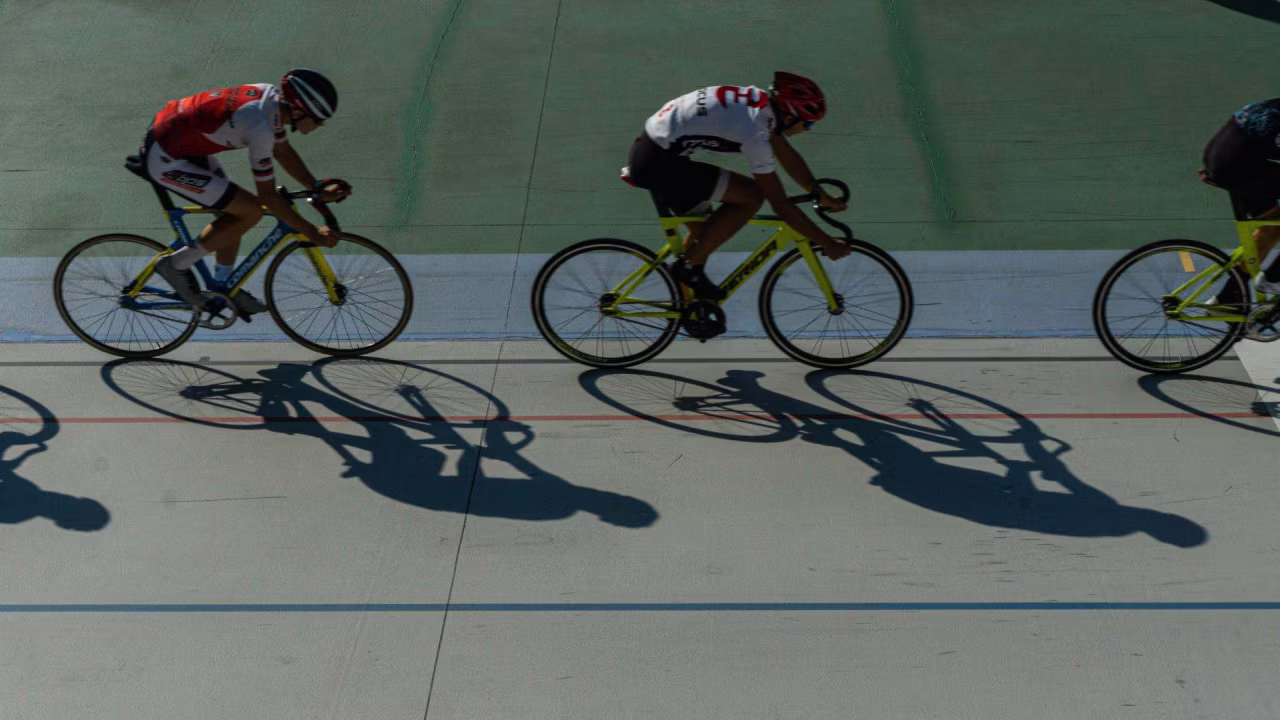 Sportoverzicht april 2022 met wielerwedstrijd op velodroom in actie en drie fietsers in intensieve race