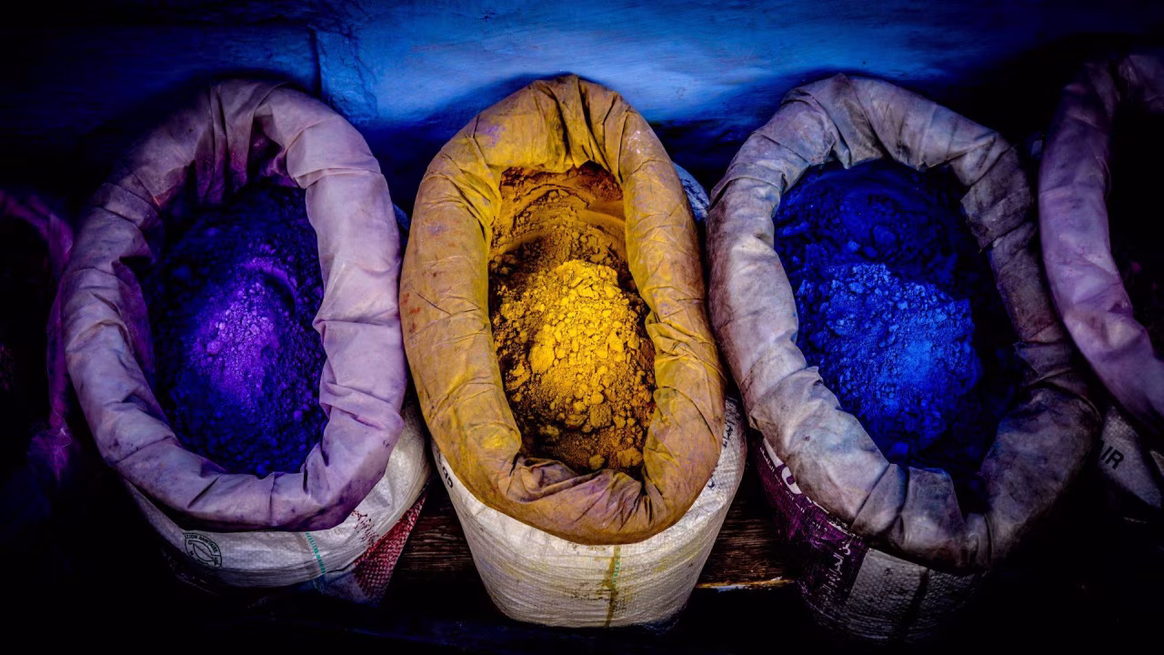 Toen is nu ambachtelijke blauwdruk met vier tassen pigmenten in paars, blauw en geel op rij gefotografeerd van bovenaf