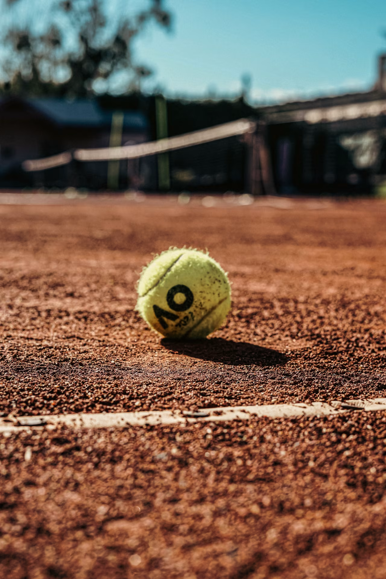 Tennisbal op gravel baan nabij witte lijn, h2 sportoverzicht van ma 24 t/m zo 30 januari 2022
