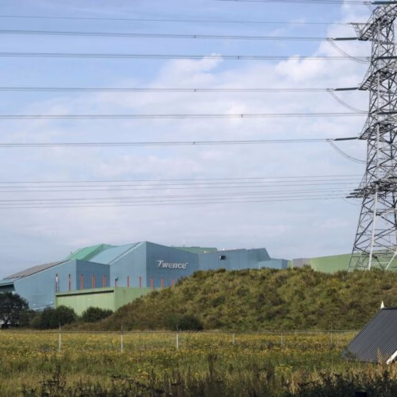 Regionaal weekoverzicht toont industrieel complex Twence met hoogspanningsmast tijdens bewolkte dag in Twente april 2022