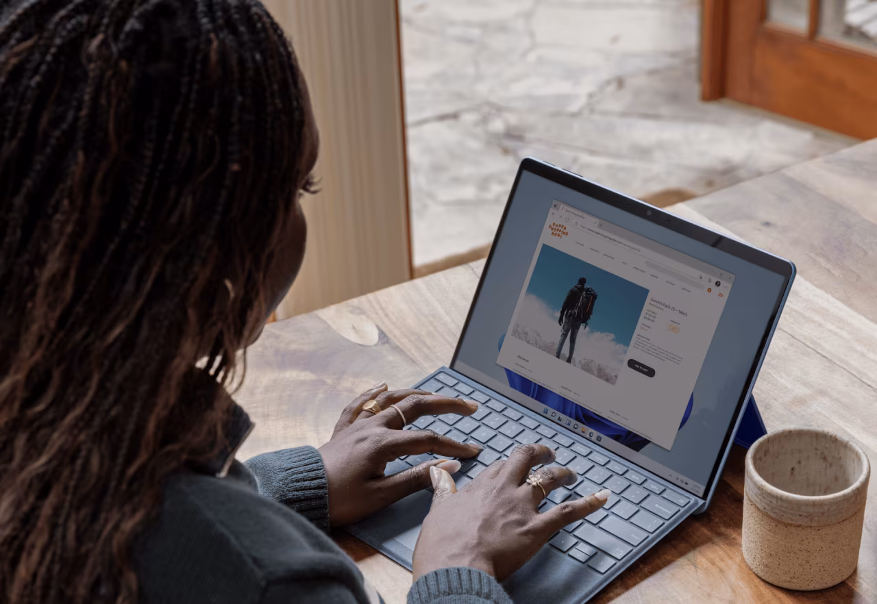Pers werkt thuis achter laptop, scherm toont website met figuur, thuiswerken dichterbij dankzij nieuwe wet