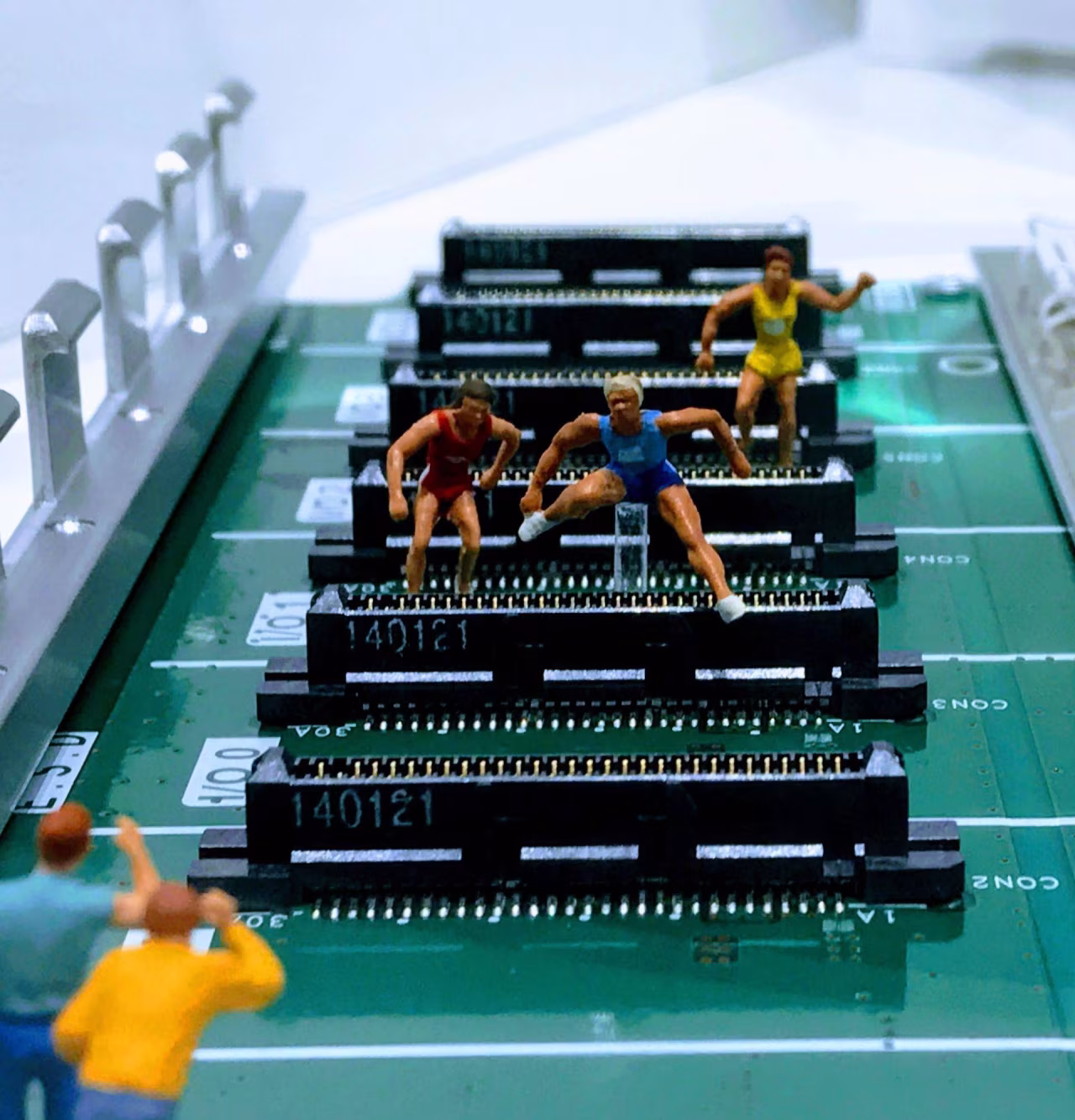 Miniatuur hardlopers op printplaat met elektronische componenten, symboliseert combinatie sport en technologie sfeerbeeld
