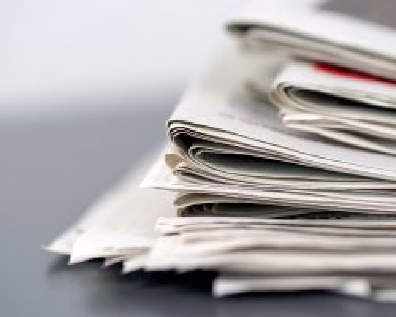 Stapels kranten op een grijze achtergrond bij het weekoverzicht van 8 tot 14 november over klimaat, economie en politiek