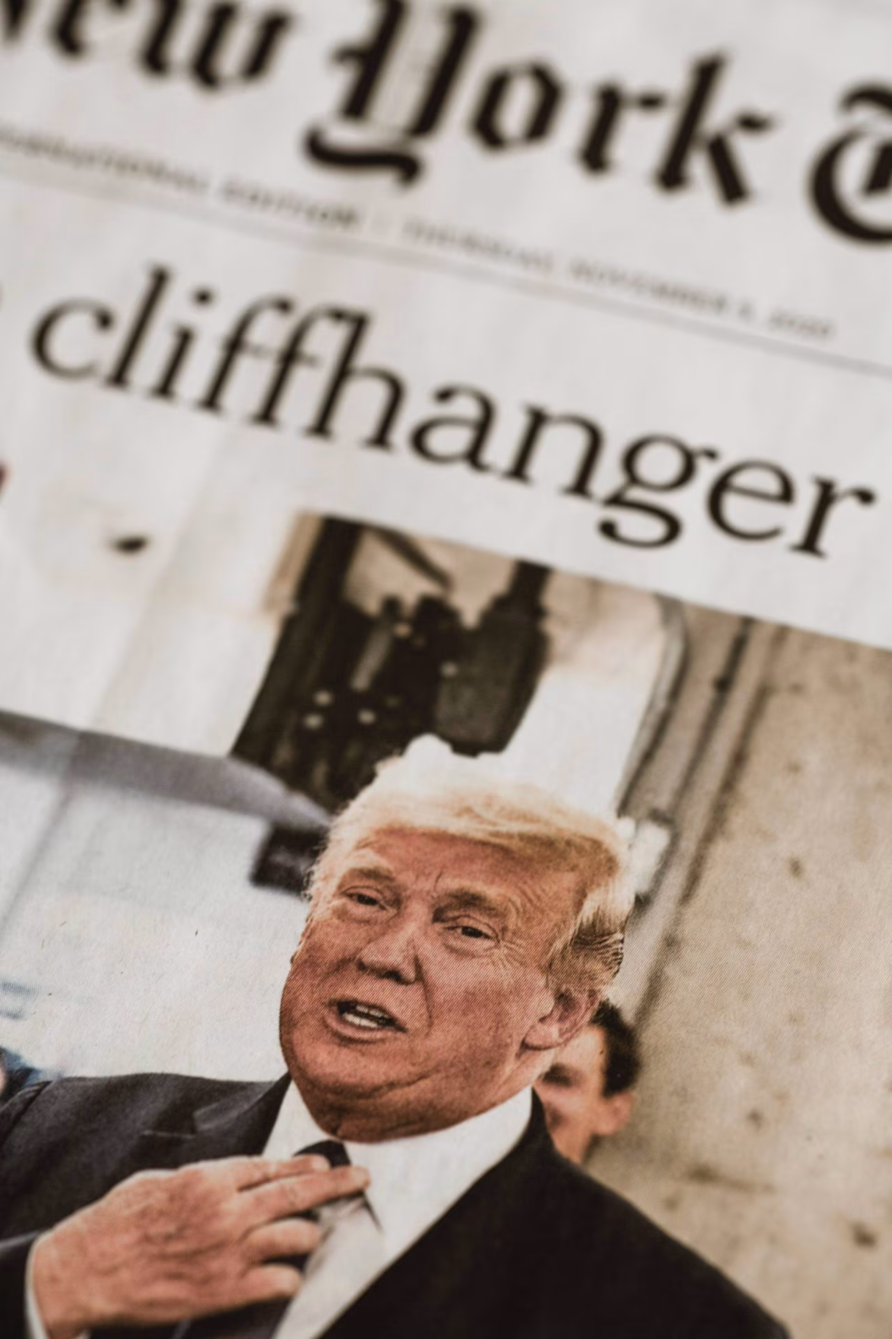 Krantenkop met 'cliffhanger' boven afbeelding van figuur met pak die das recht trekt, bij Nieuwsoverzicht 31 juli - 6 augustus 2023