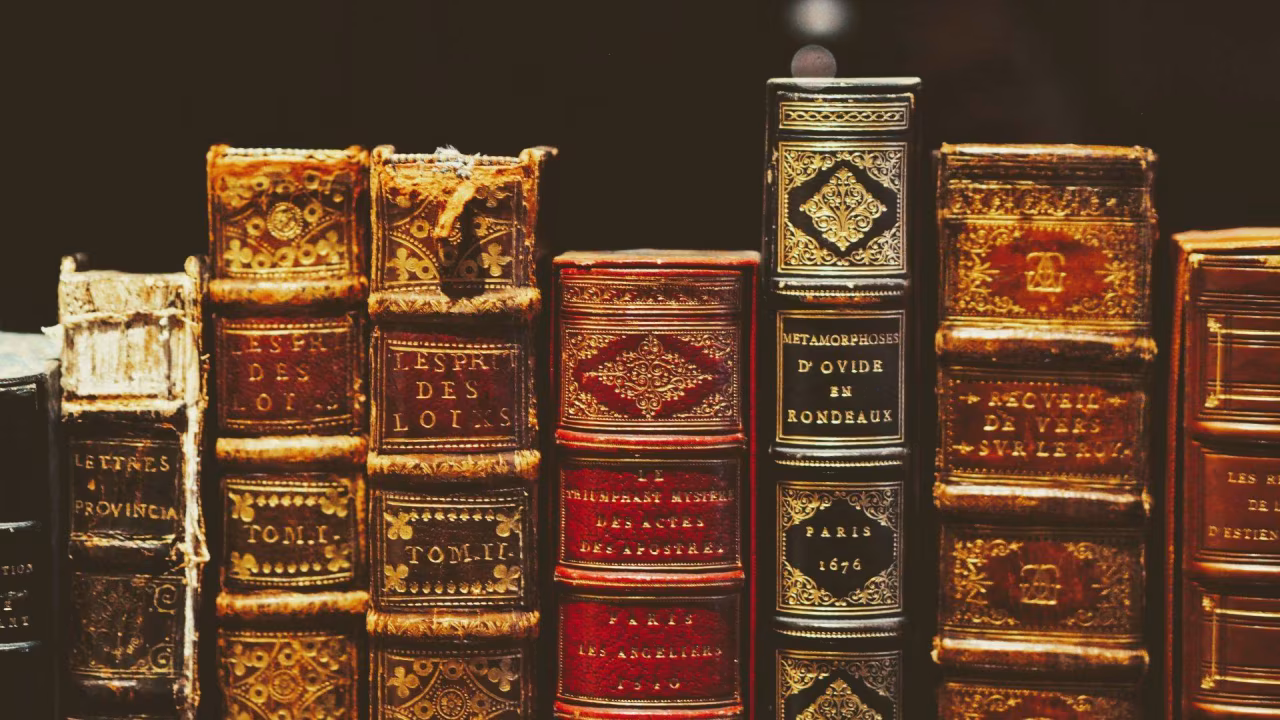 Oude franse boeken met titels als essais des lois en francois d'ovid de rondeaux op rij, klassieke kennis en tijdloosheid
