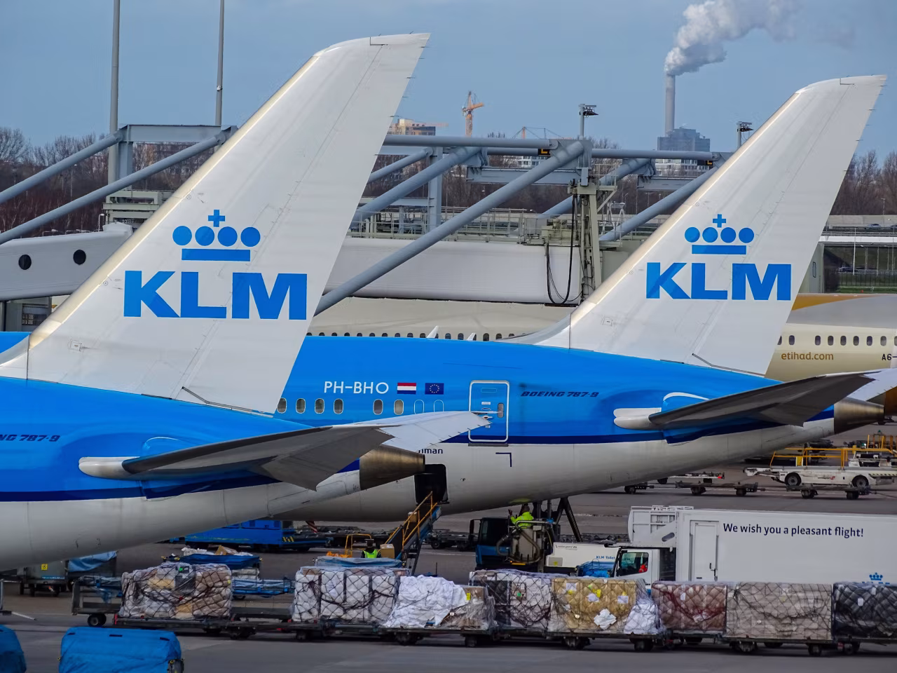 Weekoverzicht 25 april t/m 1 mei 2022 met KLM vliegtuigen op luchthaven Schiphol, staartvin PH-BHQ en bagagevoertuigen zichtbaar
