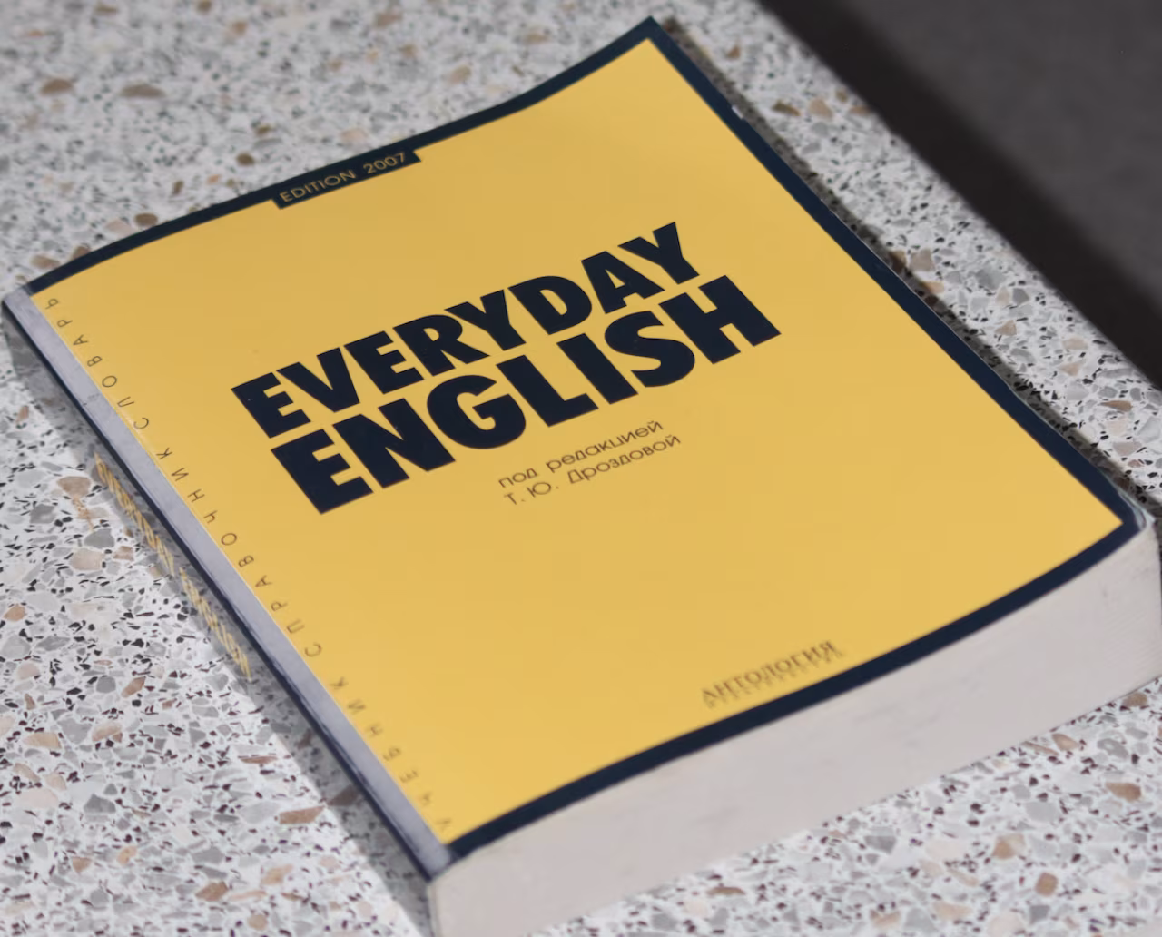 Boek everyday english van i.o. oparinova met jaartal 2007 op tafel met grindachtige steenlook onder titel uitvasief