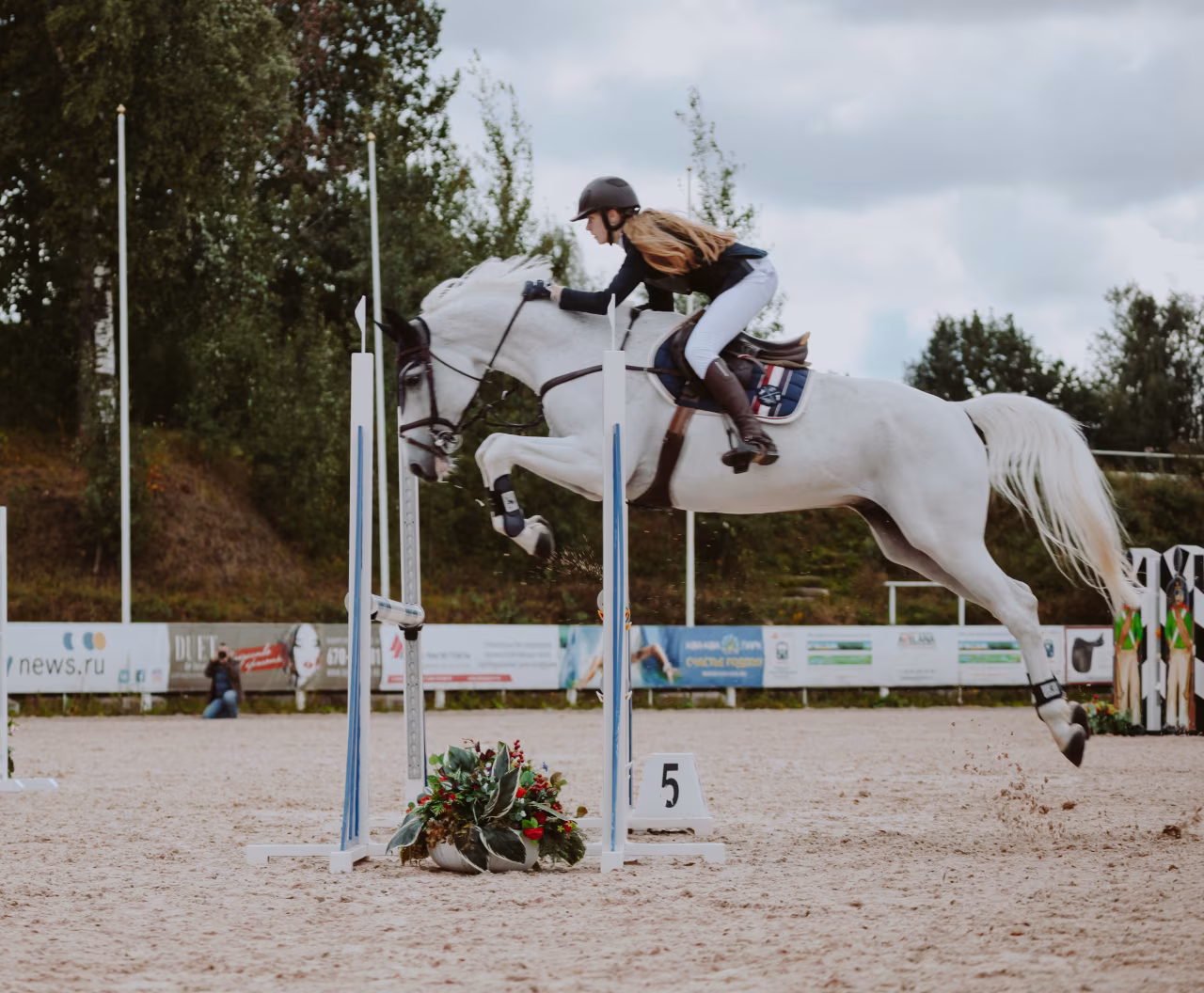 Paardensprong over blauwe hindernis met bloemendecoratie bij sportoverzicht ma 20 t/m zo 26-12 2021