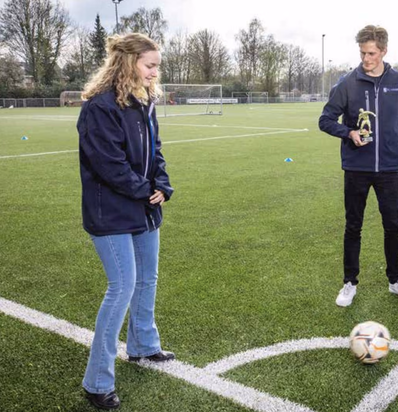 Fc noaber: jongeren beleven voetbalprestatie met bal en trofee op kunstgrasveld tijdens prijsuitreiking
