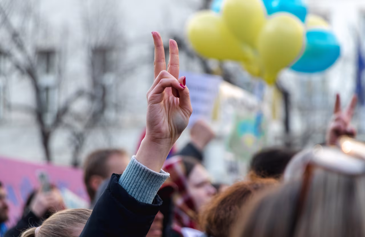 V-teken symbool voor vrede bij menigte op bijeenkomst. Nieuws over de oorlog in Oekraïne, april 2022 bij TKKR