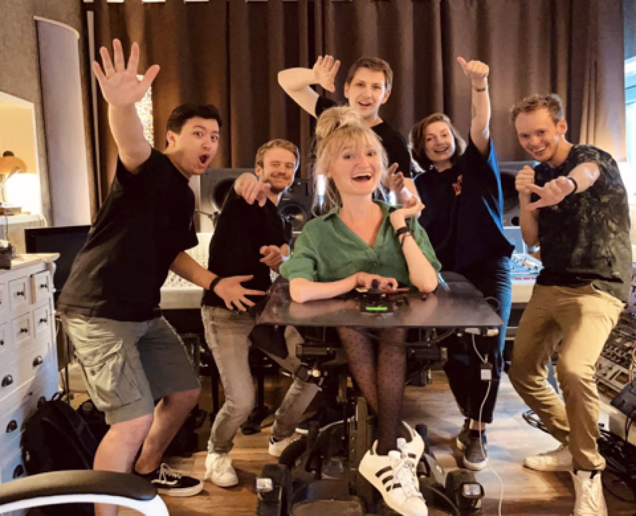 Debuut-album silke veld dankzij crowdfund-actie zes mensen vieren succes rond tafel in rolstoel vrolijk