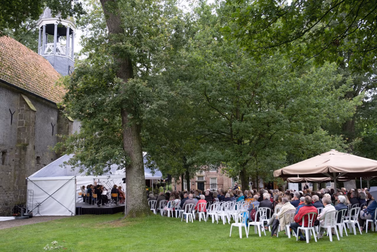 Zeventiende Stiftfestival buitenbijeenkomst met podium en publiek bij Stiftskerk in Weerselo, muziekfestival met hartstocht en emotie