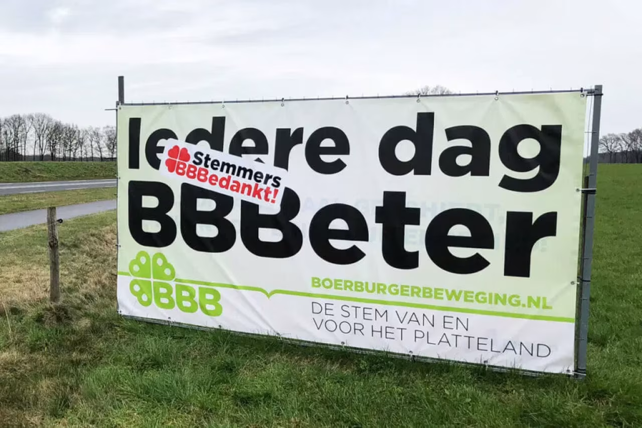 Spandoek met politieke tekst 'Iedere dag BBBeter' en 'stemmers BBBedankt!' van BoerBurgerBeweging langs grasveld; focus op platteland en BBB