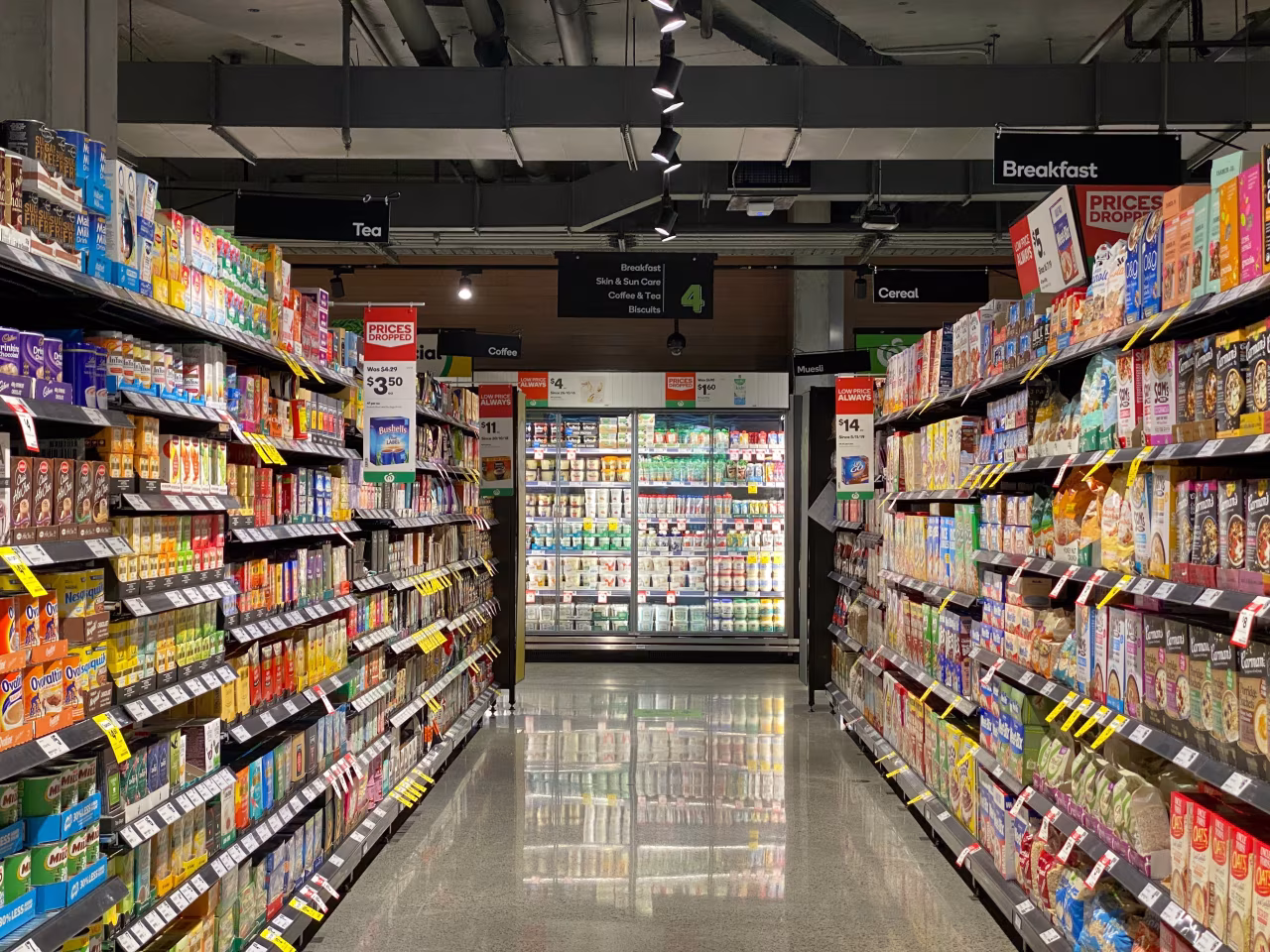 Gang supermarkt met borden breakfast cereal prices en koelafdeling gang vol ontbijtproducten weekoverzicht 10-16 januari 2022
