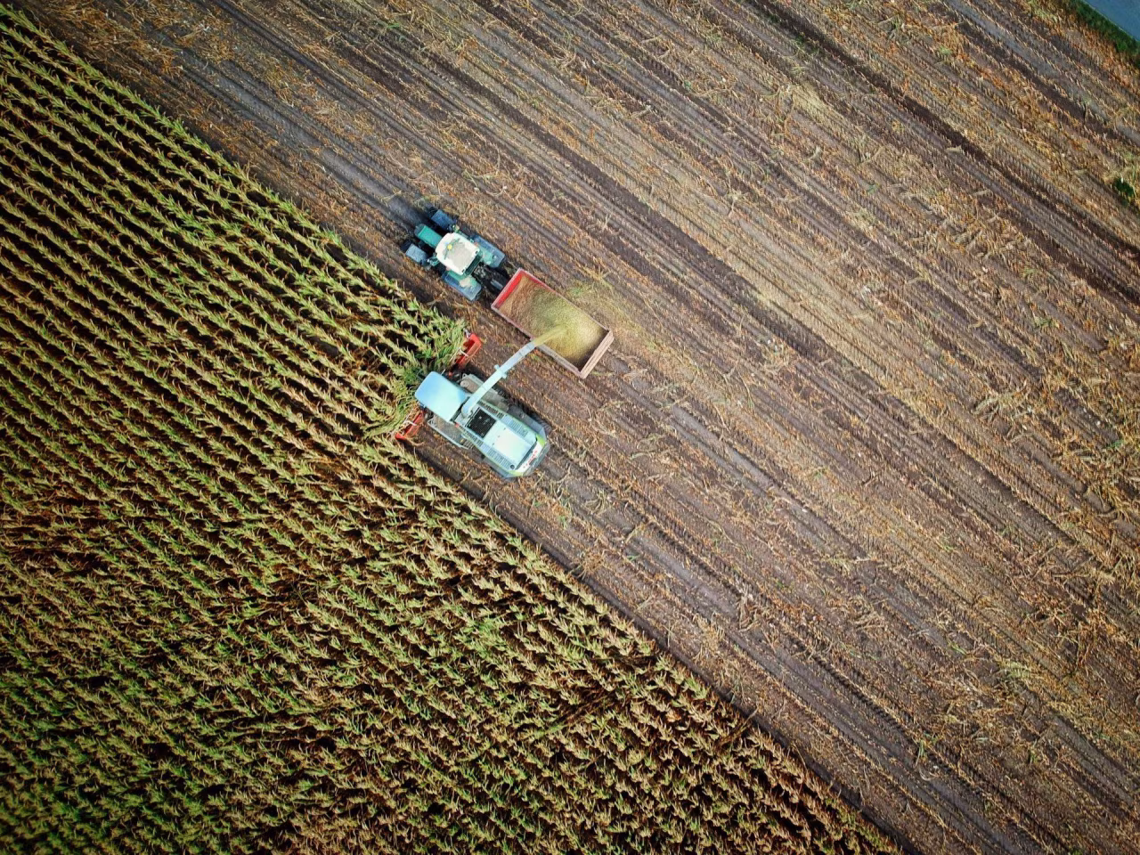 Luchtfoto landbouwgebied met machines die oogsten voor toelichting hulp boeren zonder vergunning uit TKKR
