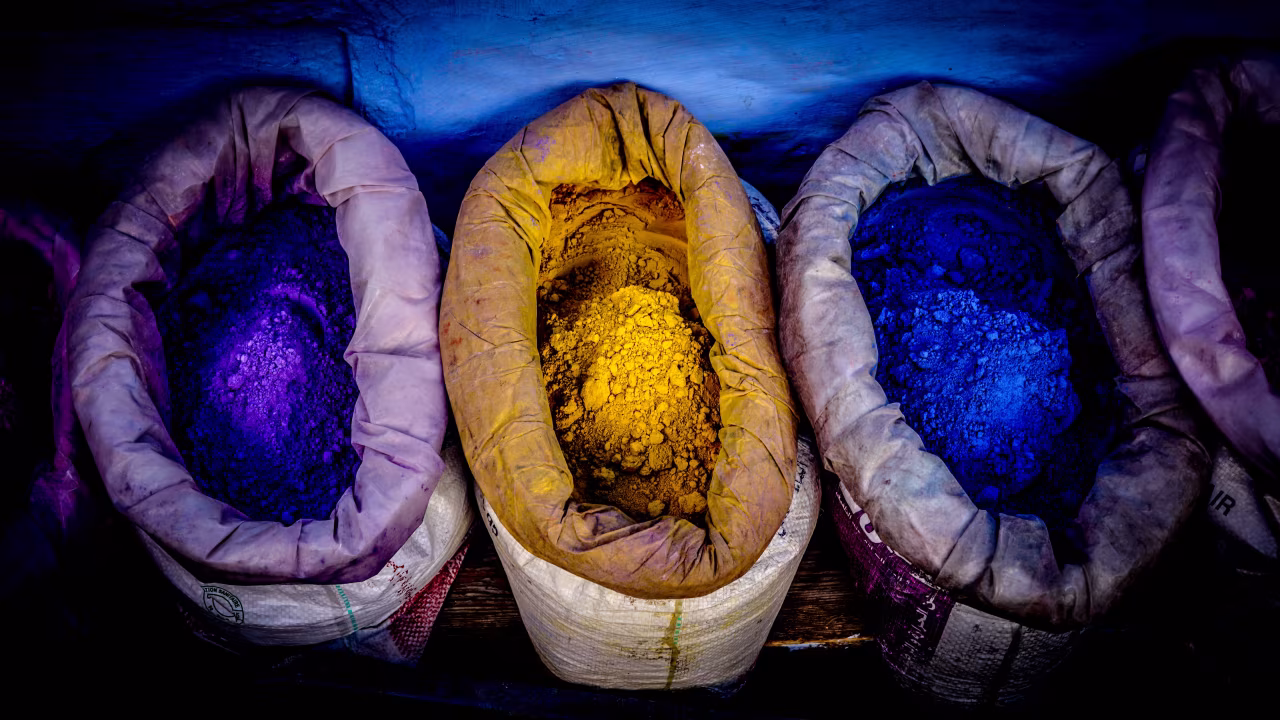 Toen is nu ambachtelijke blauwdruk met vier tassen pigmenten in paars, blauw en geel op rij gefotografeerd van bovenaf