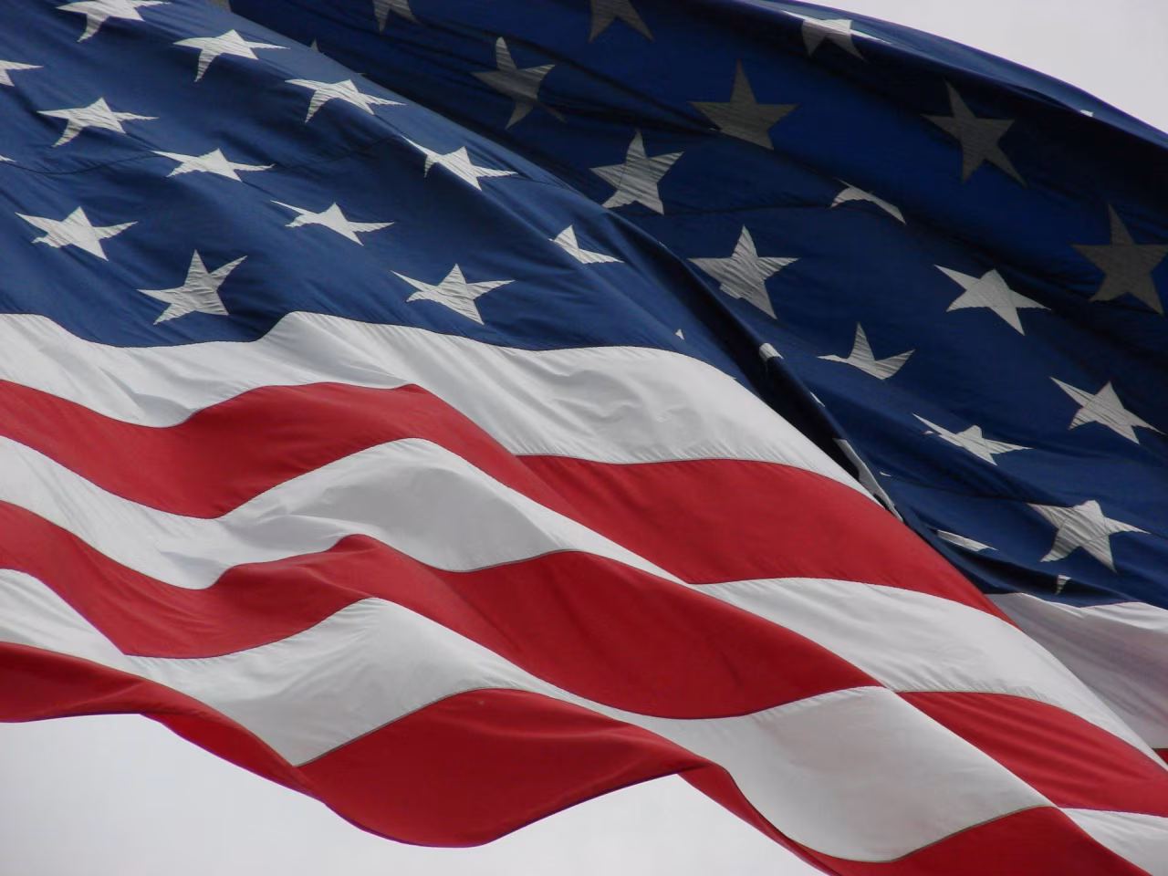 Nieuwsoverzicht 20-26 jan 2025 met close-up Amerikaanse vlag: witte sterren, rode witte strepen wapperend in wind
