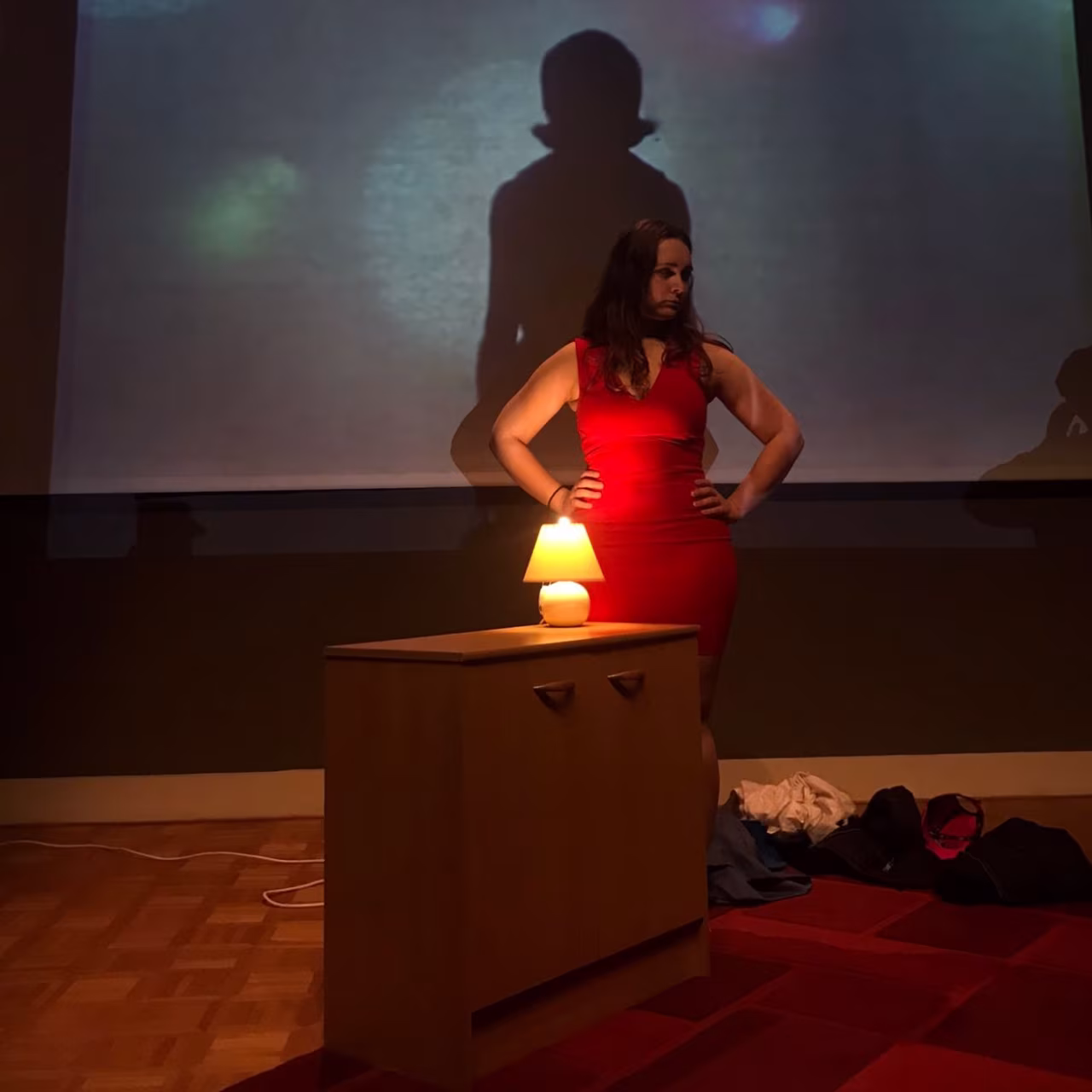 Artemisia by Night: intieme scène met rode jurk en schaduw bij kastje met lamp tijdens theatervoorstelling in Rijksmuseum Twenthe