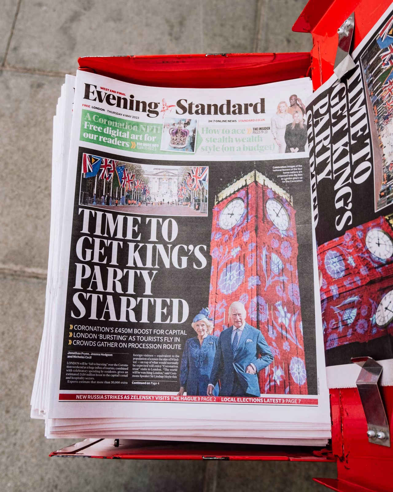 Krantenbak met rood rode krant dispenser en stapel evening standard met kop time to get king's party started en big ben illustratie op voorpagina