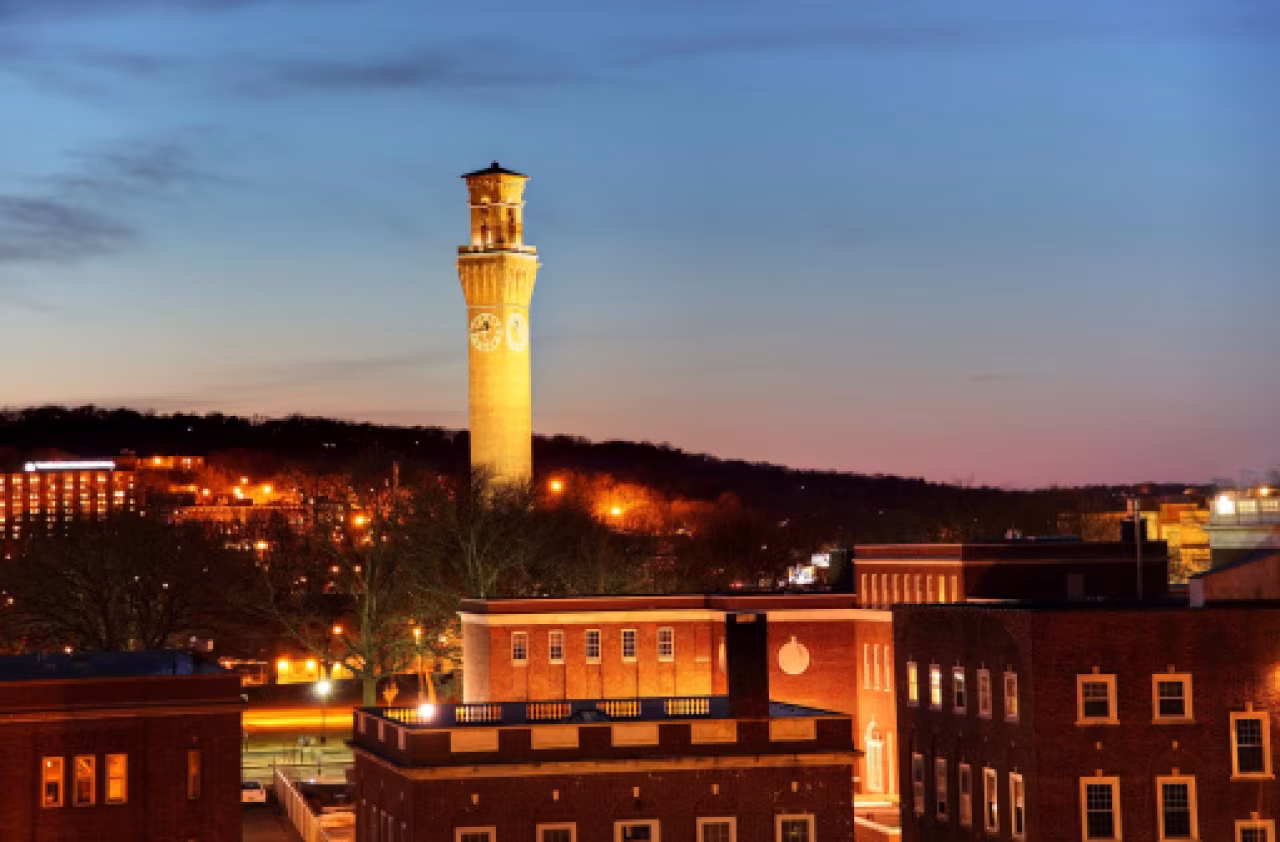 Waterbury stadsgezicht bij schemer met verlichte kloktoren centraal - Twentse Trekken op Bijzondere Plekken