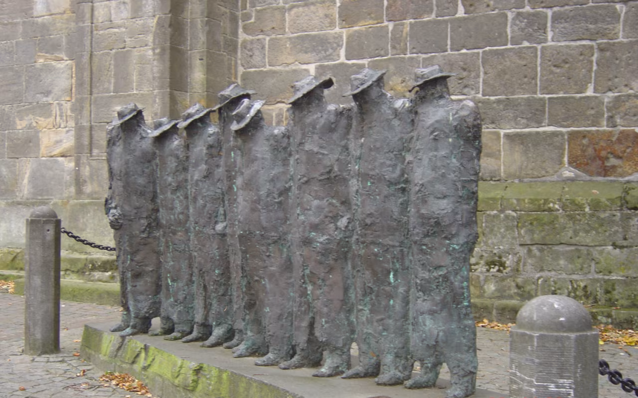 Beeldhouwwerk zeven bronzen figuren zonder hoofd op sokkel tegen stenen muur regionaal weekoverzicht 16-20 jan 2023