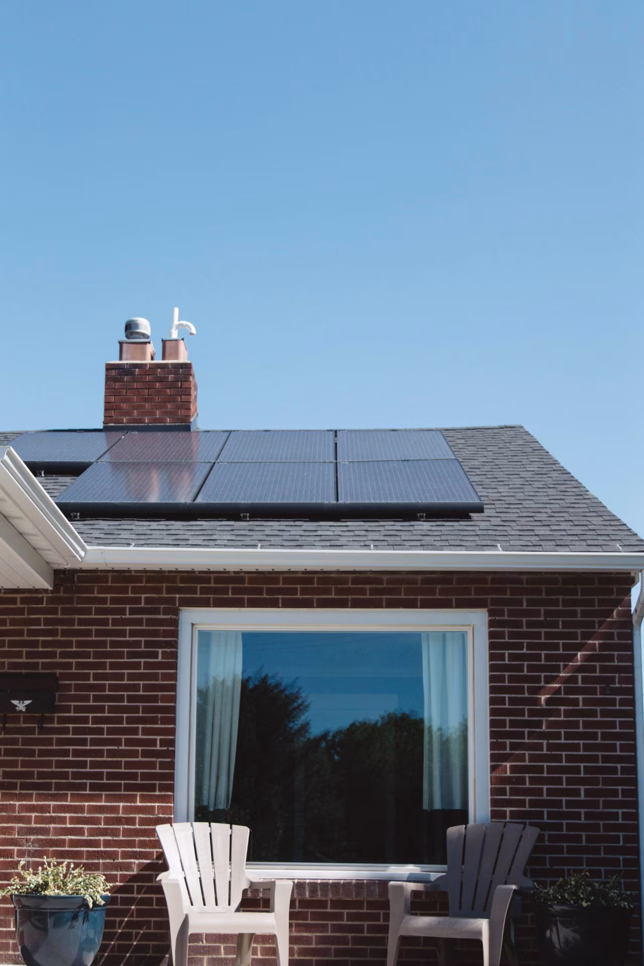 Duurzaam huis met zonnepanelen op dak onder blauwe lucht bij artikel over vol elektriciteitsnet door zonnepanelen
