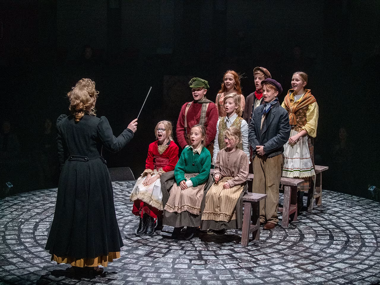 Jong talent gezocht voor musical Scrooge scène met groep zingende kinderen en dirigent in theater