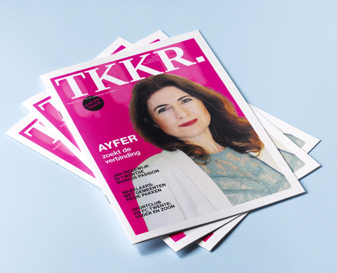 Voorblad van TKKR magazine met helderroze achtergrond en grote tekst TKKR. Ayfer zoekt de verbinding staat centraal