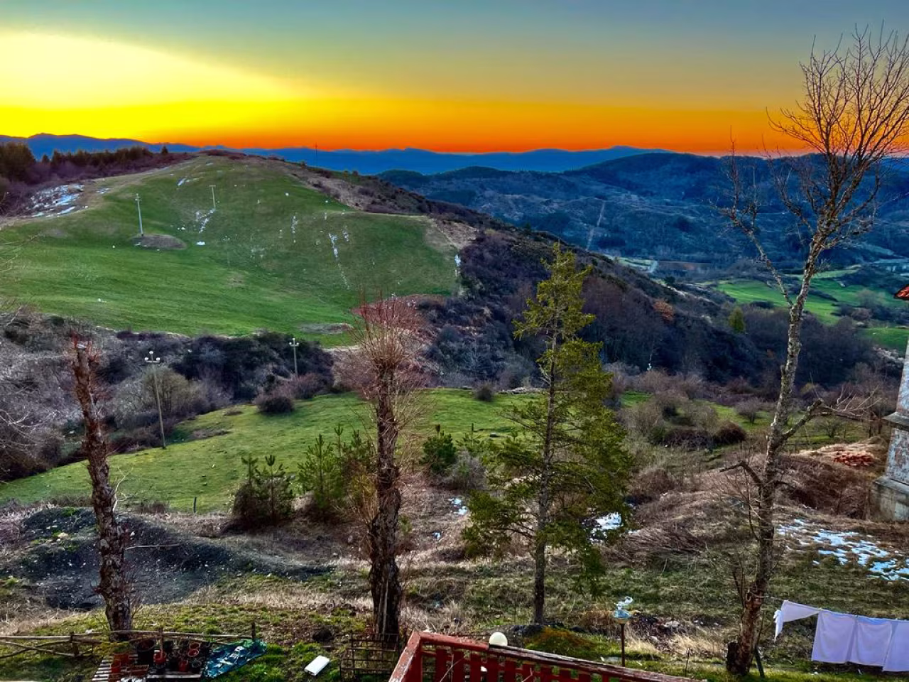 Rustig berglandschap bij zonsondergang met groene heuvels en bladloze bomen in natuur, ik pelgrimeer daarom denk voel