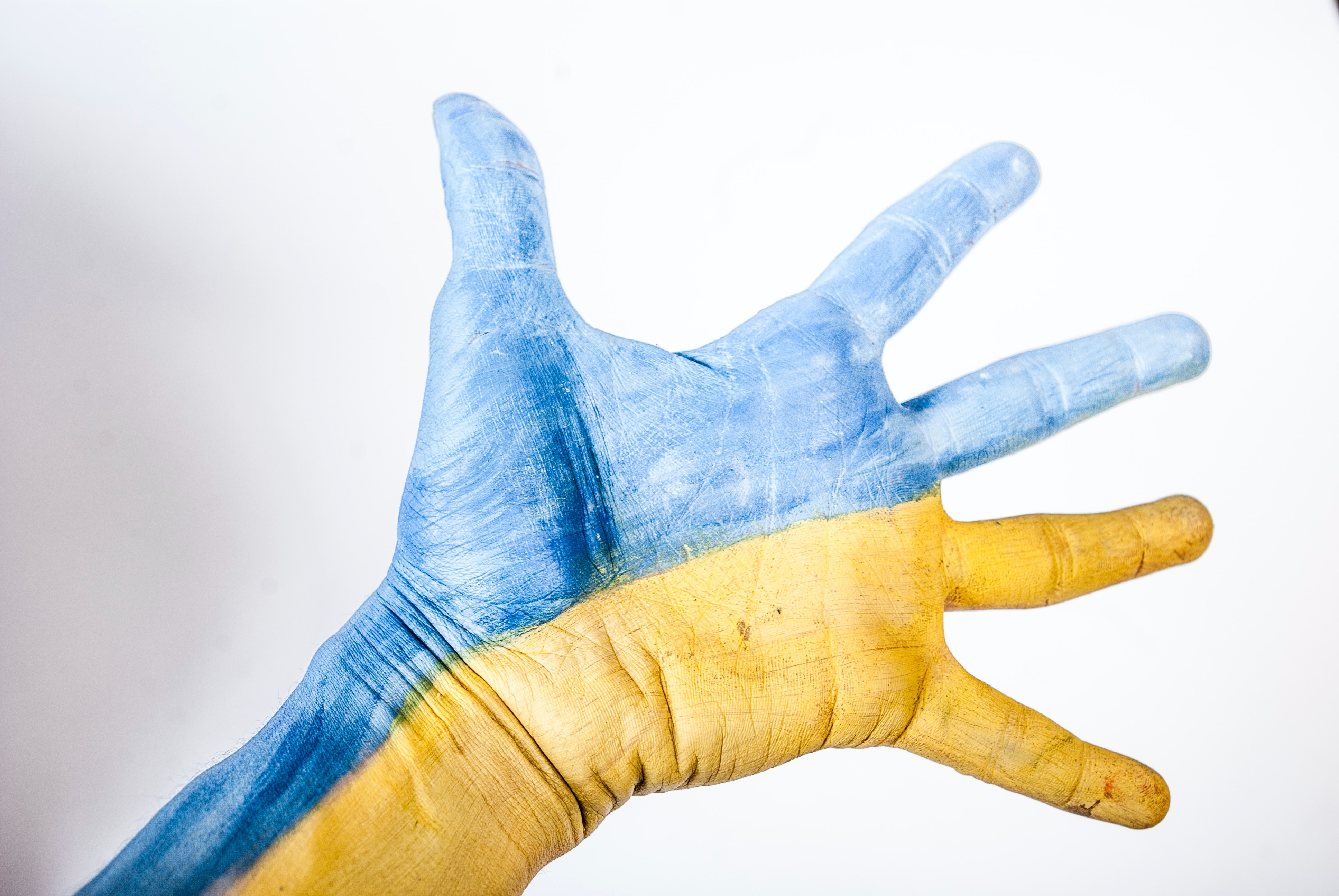Hand met horizontale blauwgele kleuren als symbool van steun aan Oekraïne, oorlog in Oekraïne juli 2024